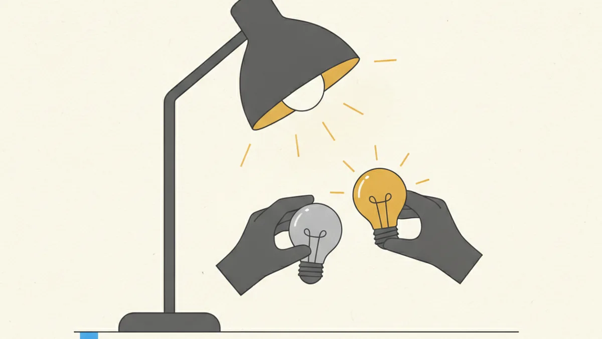 A hand swaps a dull grey lightbulb for a bright gold one while the desk lamp stays lit